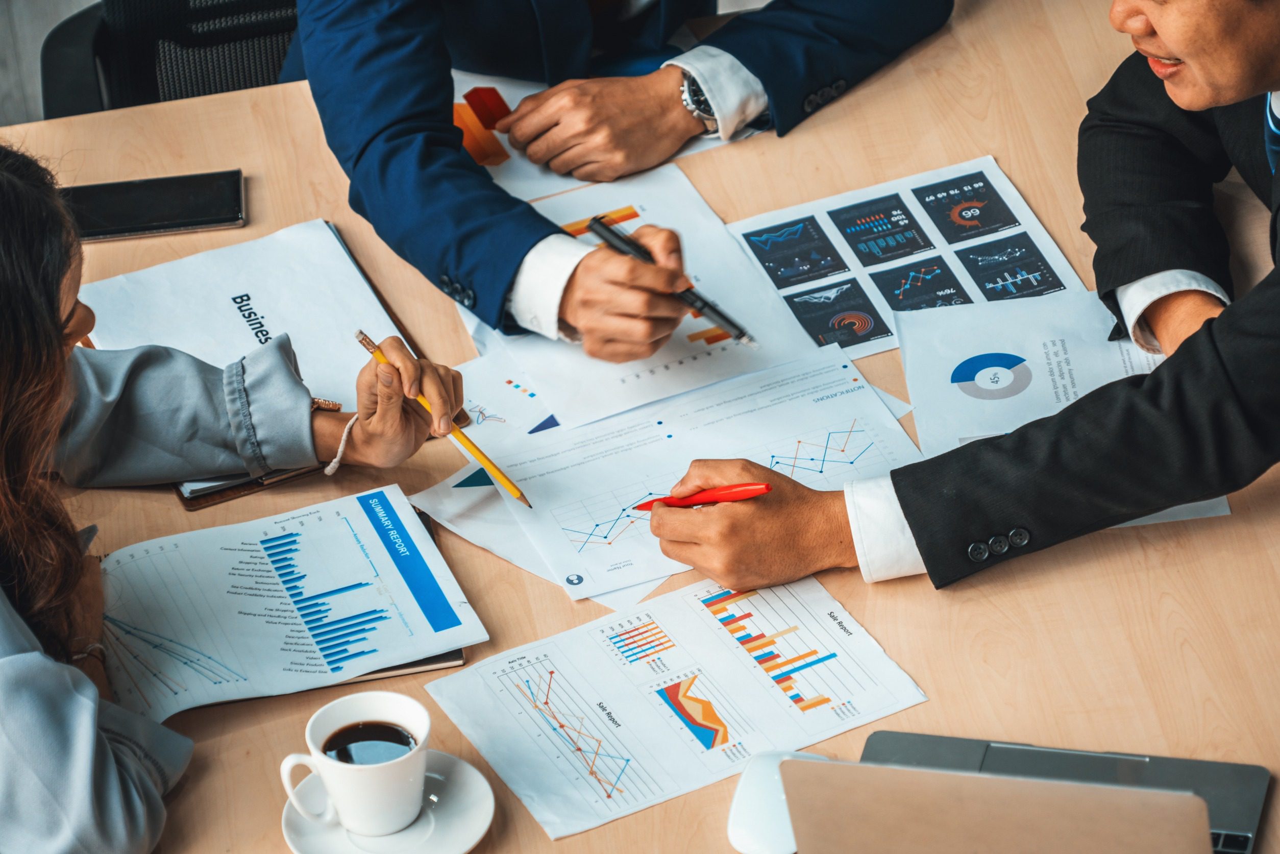 Businessmen discuss tables and charts