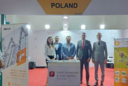pracownicy PAIH stojący na tle logo Agencji