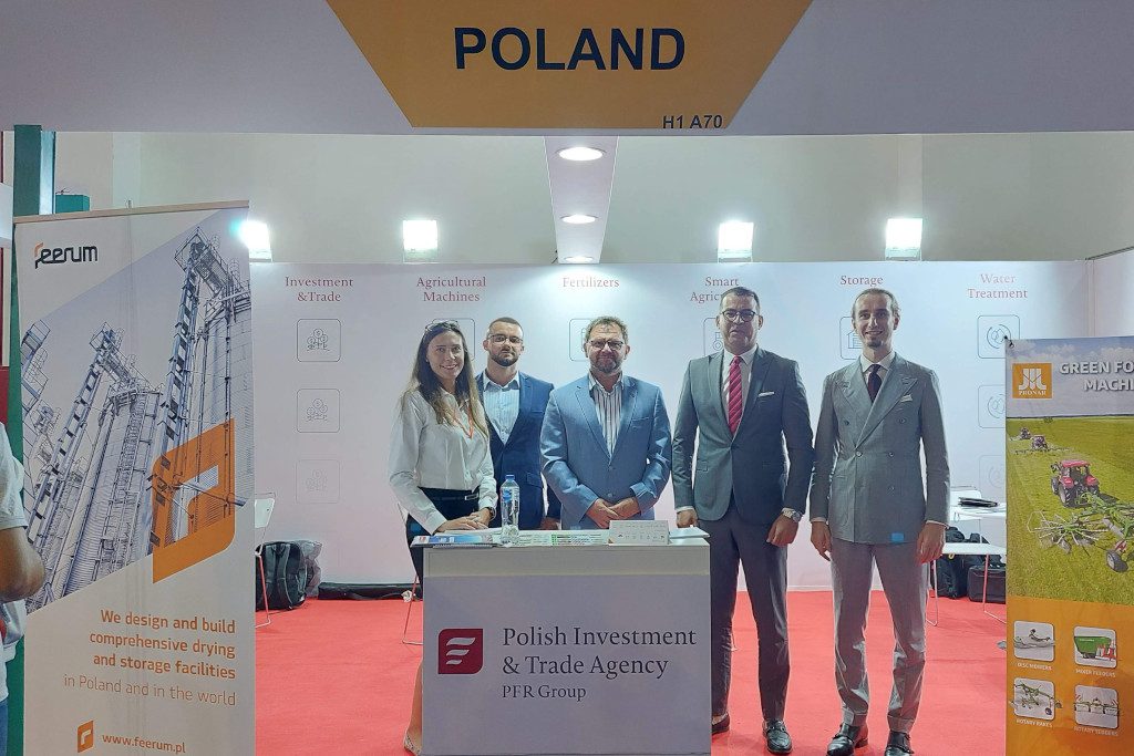 pracownicy PAIH stojący na tle logo Agencji