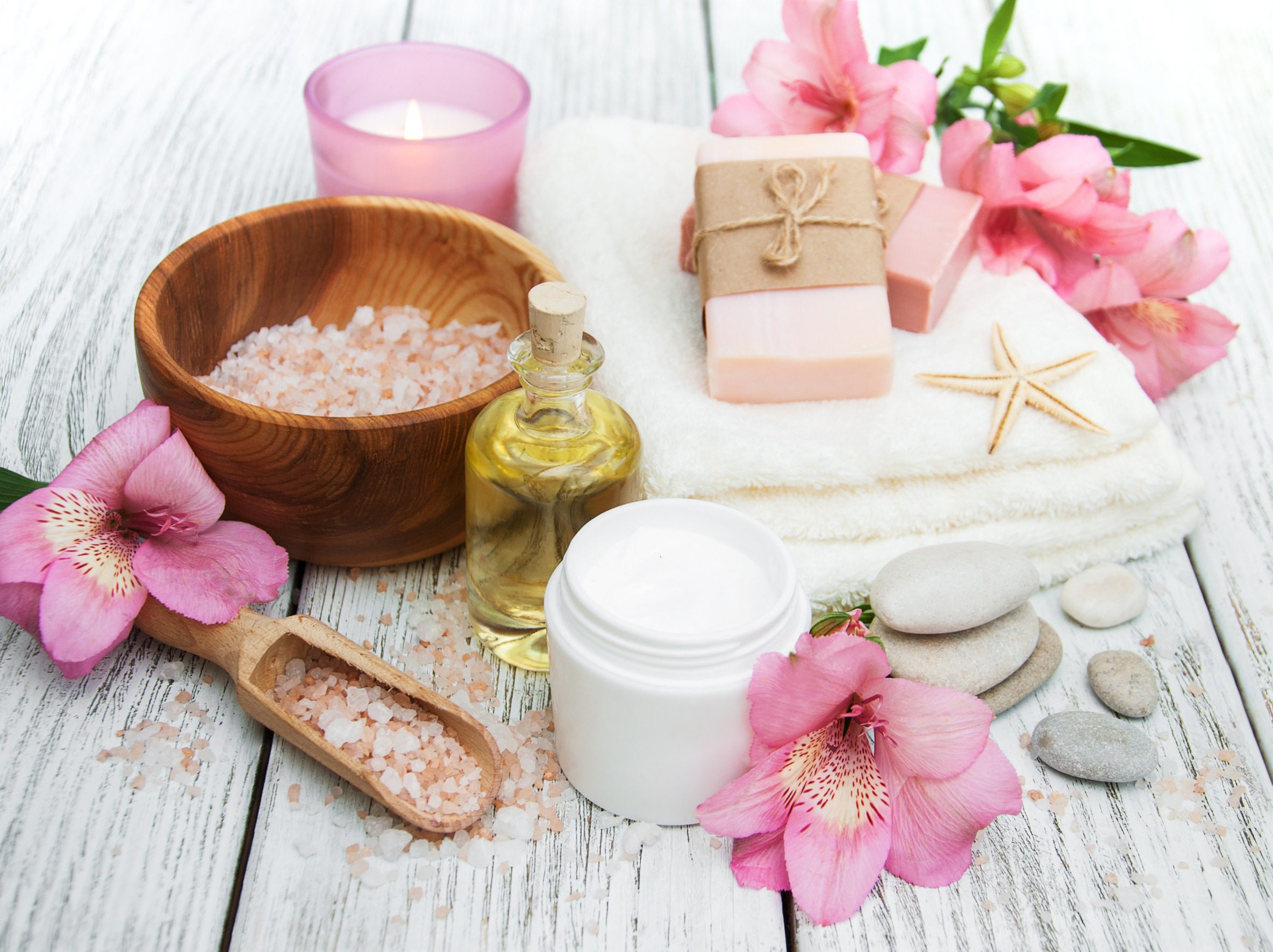Spa cosmetics with alstroemeria flowers on a wooden background