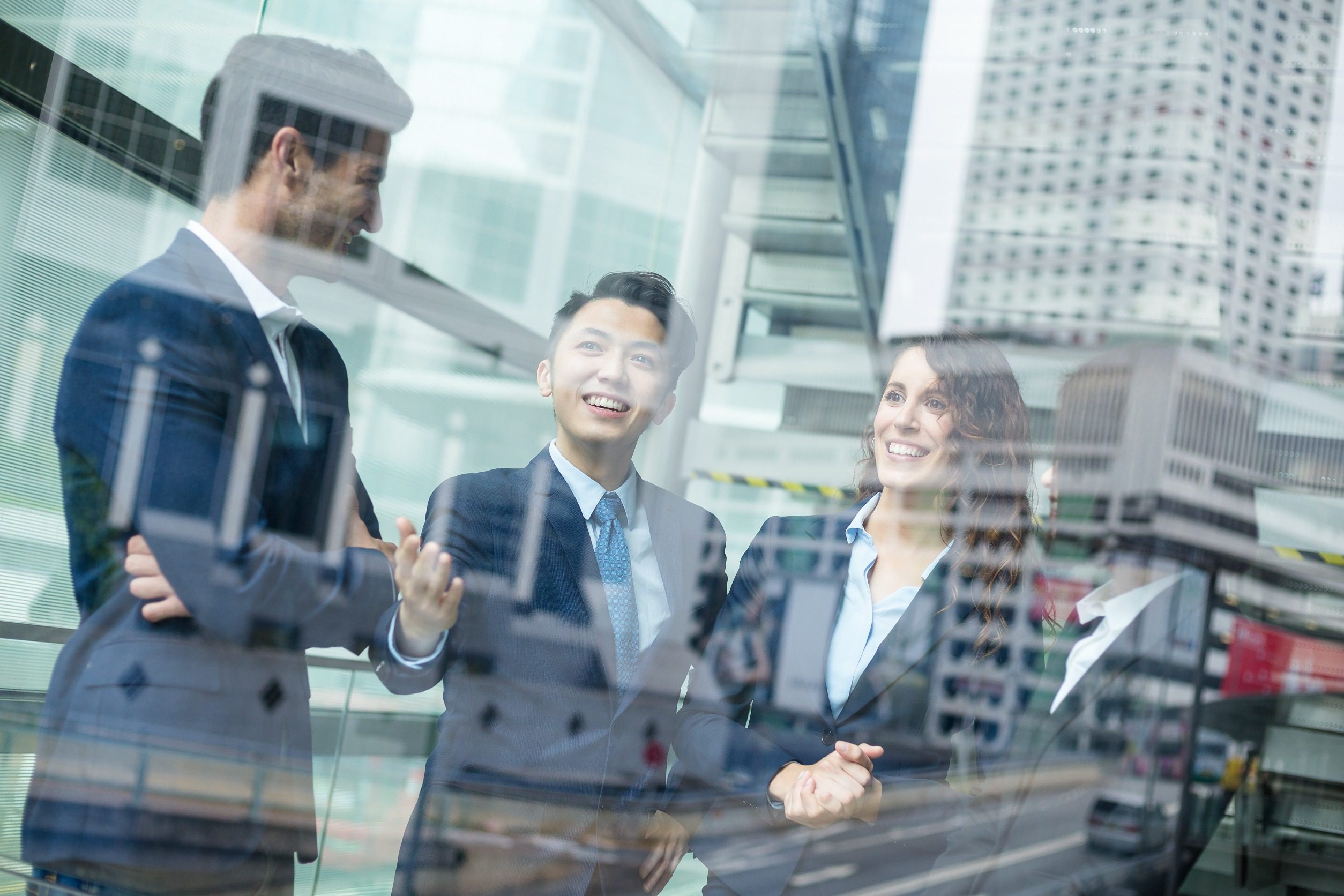 Young businessmen talk against the backdrop of modern office buildings