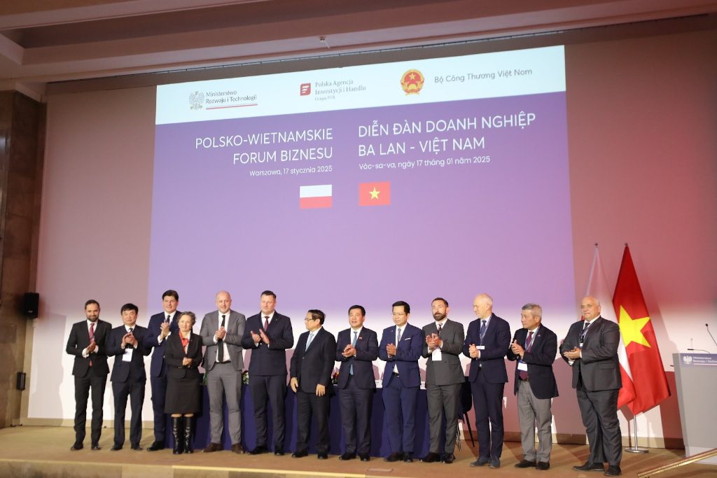 Political and business representatives of Poland and Vietnam stand on stage
