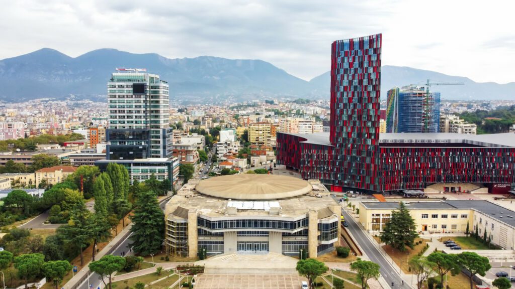 Albania - widok z lotu ptaka na centrum Tirany w Albanii z nowoczesnymi budynkami, stadionem, dzielnicą mieszkaniową i górami w oddali