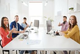 A 6-person creative team sits in a conference room at a long white table.