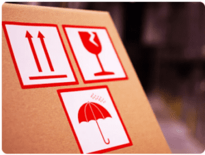 Logistics and warning labels applied on cartons and pallets with handling and hazard symbols visible