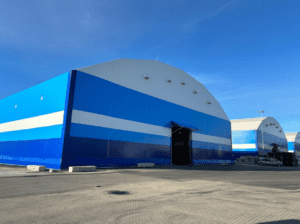 Steel hall for industrial use with durable structure, large access doors, and fast installation capability.